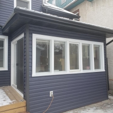 New Royal estate siding in Marine Blue color with accented ironstone corners. Front gable done in Portmouth Shake Gray Moss color. All Weather patio door installed in place of a 32 exterior door. All soffit, fascia and eaves done in black to tie it all 